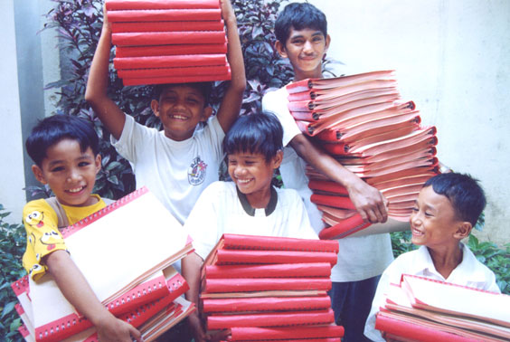 Children carrying the many volumes of a braille Bible